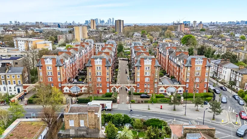 Red-brick mansion blocks with the City skyline beyond, drone property photography London