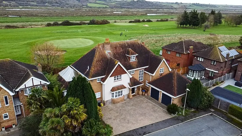 Detached house beside open green space from above, drone property photography London