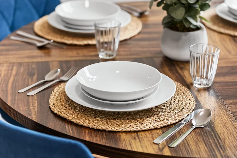 Walnut dining table laid with rattan placemats and white plates, Airbnb photography London