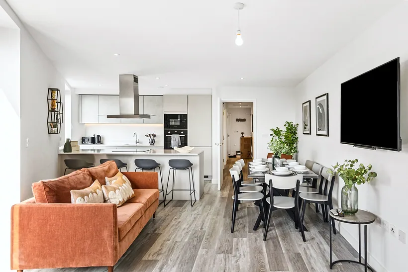 Bright open-plan living room and kitchen with an orange sofa, Airbnb photography London