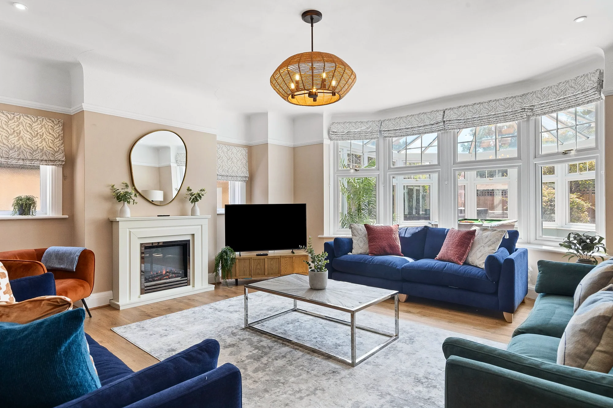 Bay-window living room with blue sofas and a fireplace, Airbnb photography London