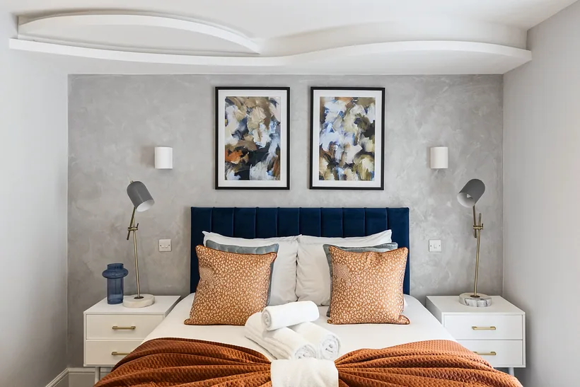 Dressed double bedroom with cushions and throws, Airbnb photography London