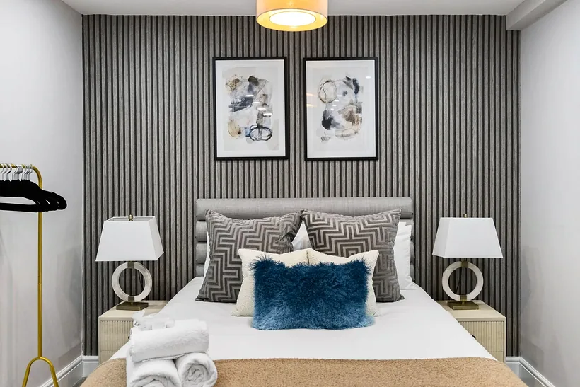Bedroom with a slatted feature wall and paired lamps, Airbnb photography London