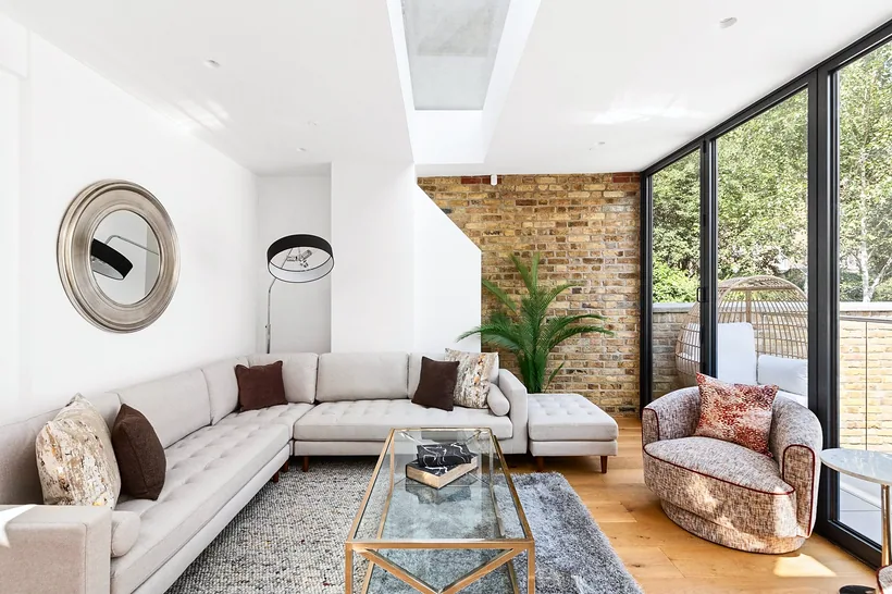 Curved sofa living with brick wall and glazing, Airbnb photography London