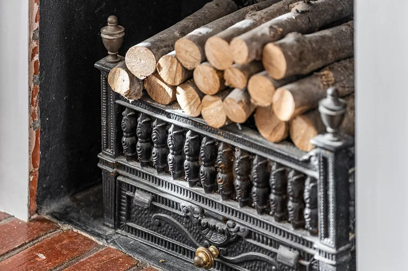 Striking log-store fireplace detail, rich texture, Airbnb photography London