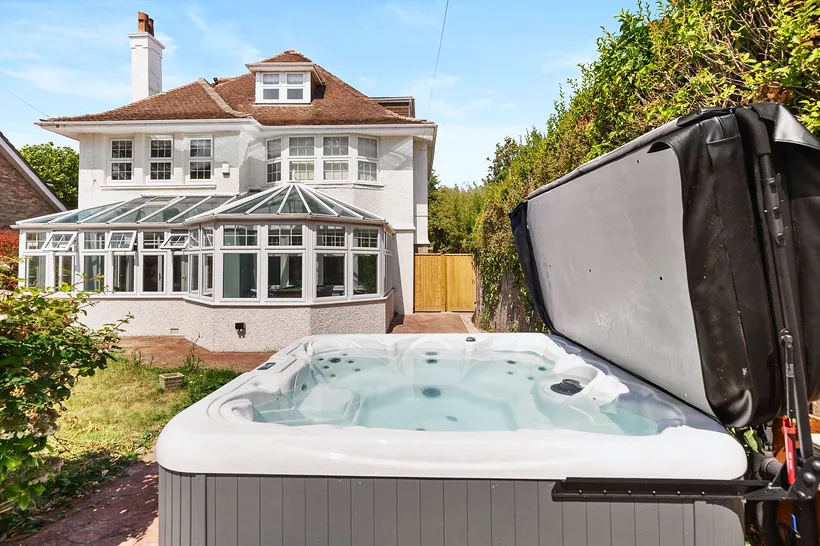 Hot tub in garden with large house behind, Airbnb photography London