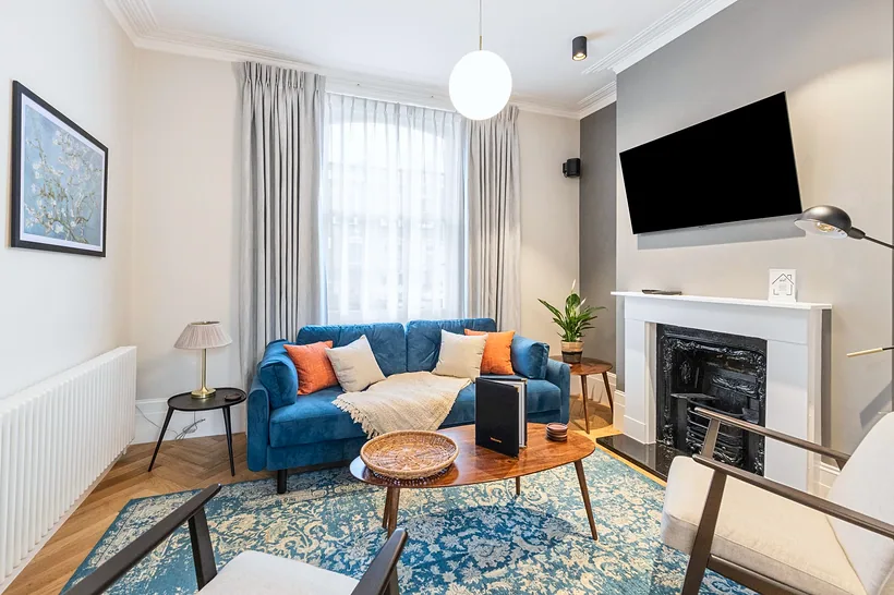 Blue sofa living with fireplace and rug, Airbnb photography London