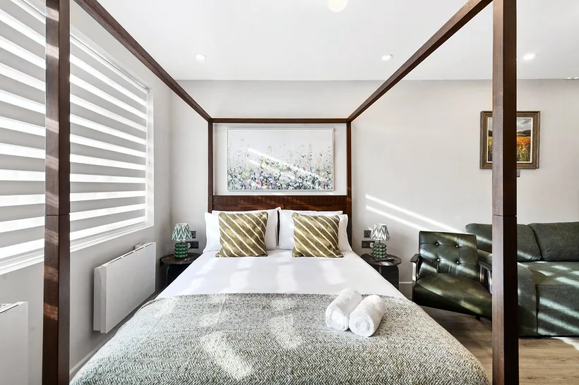 Dark-wood four-poster bed, symmetrical and fresh, Airbnb photography London