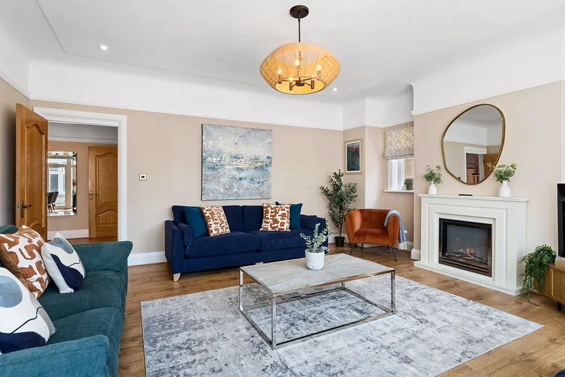 Living room with a navy sofa, marble table and fireplace, Airbnb photography London