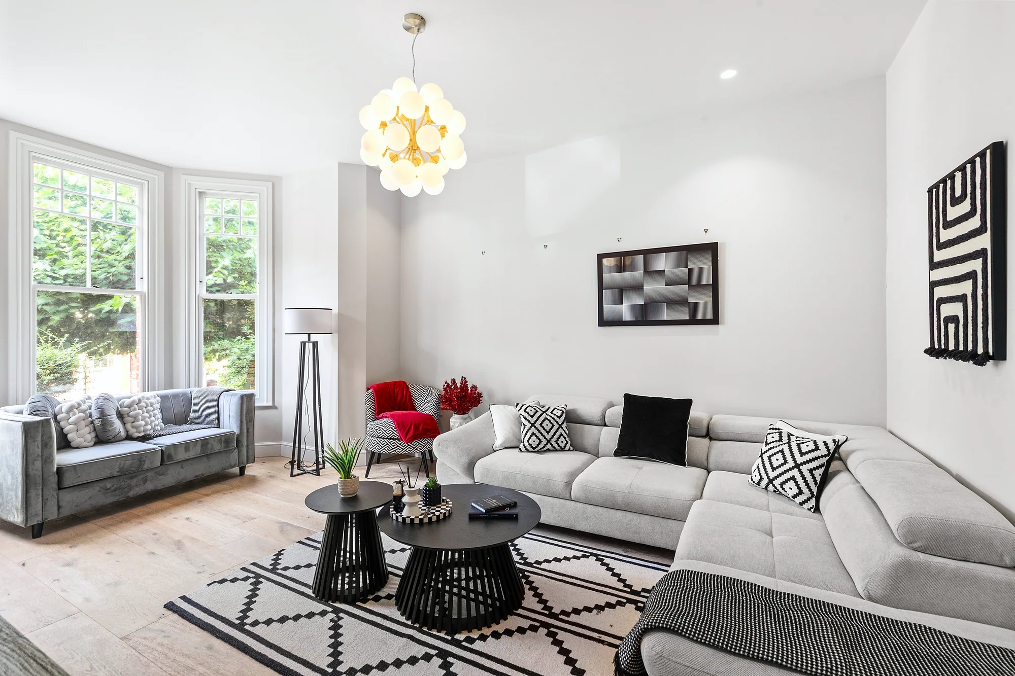 Bright living room with grey sofas and a glass chandelier, Airbnb photography London