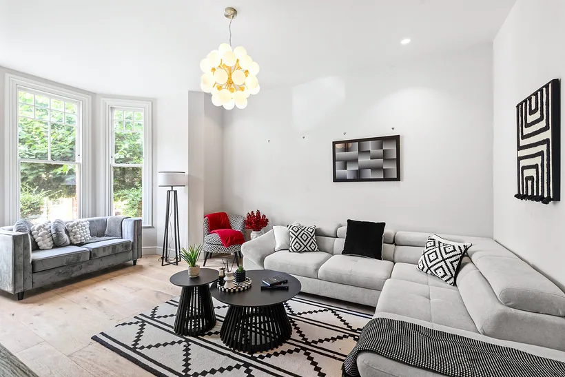 Bright living room with grey sofas and a glass chandelier, Airbnb photography London