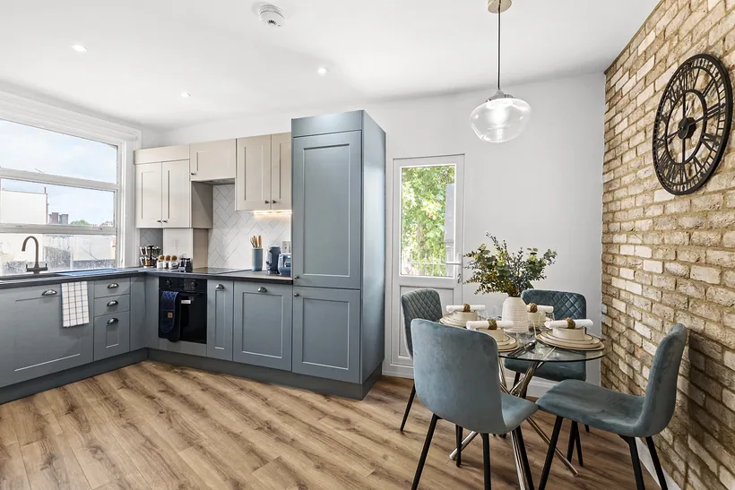Blue-grey kitchen with a dining table by the window, Airbnb photography London