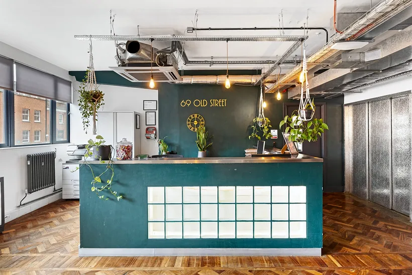Teal reception desk under hanging plants, commercial photography London