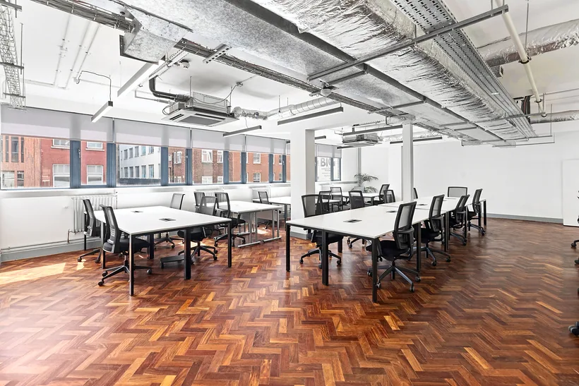 Open office with exposed ducts and a parquet floor, commercial photography London