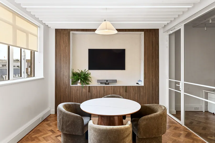 Meeting room with a walnut wall and round table, commercial photography London