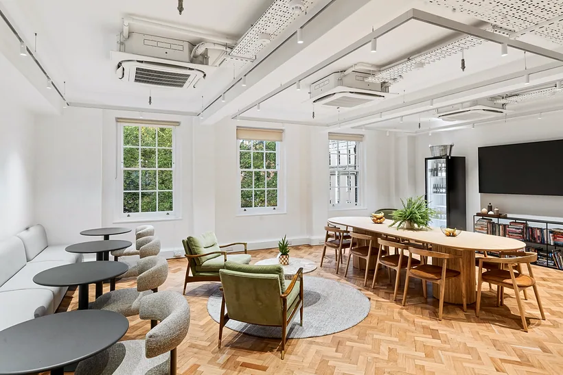 Breakout space with booth seating and a long dining table, commercial photography London