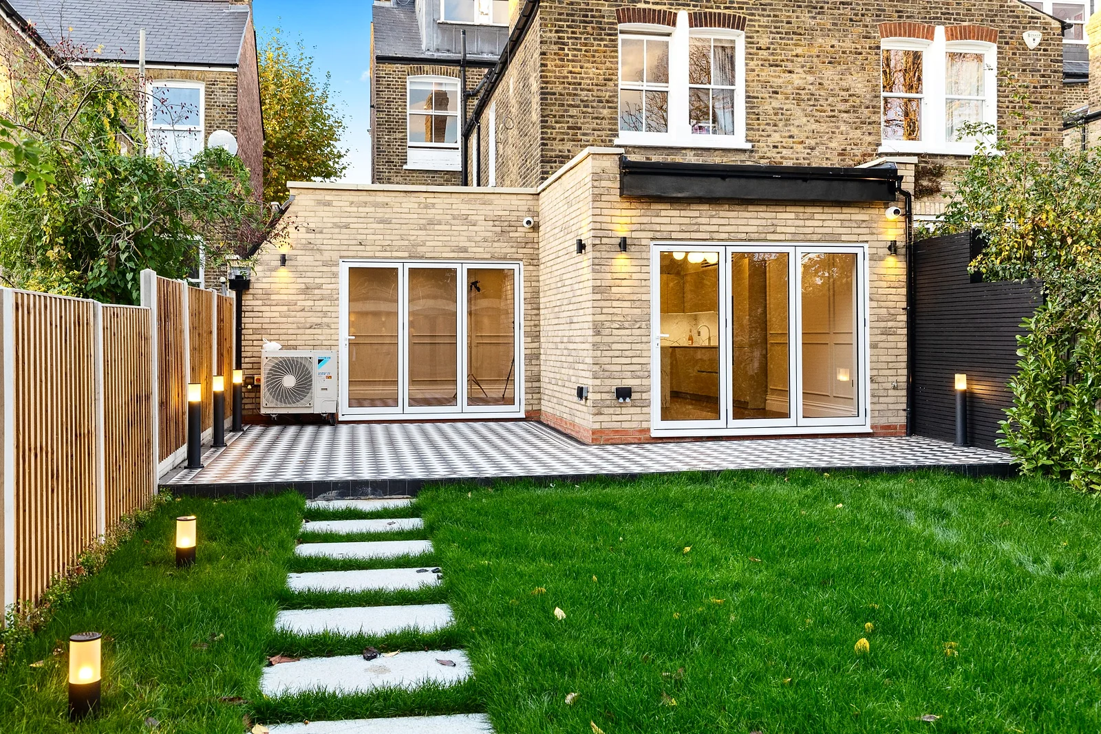 Rear extension with French doors and a lit garden path, developer photography London