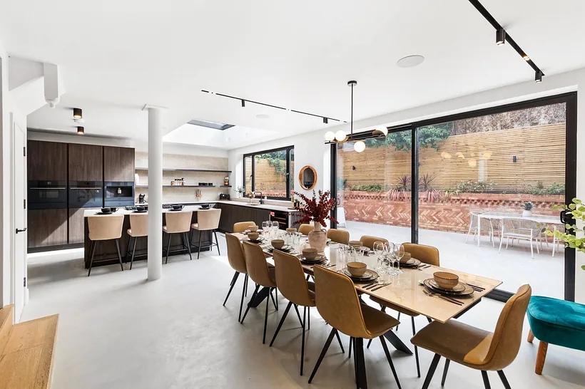 Long dining table to garden doors, bright and straight, developer photography London
