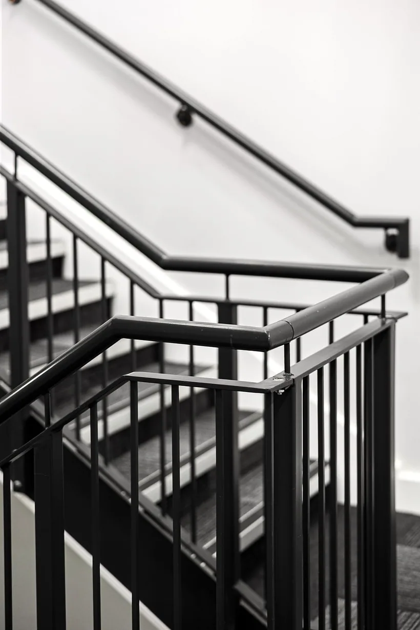 Black steel staircase spiral, graphic architectural detail, developer photography London