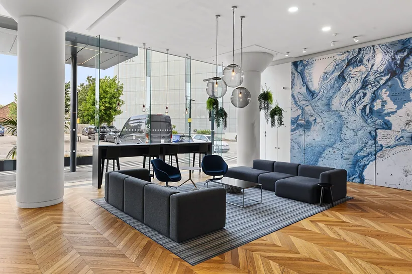 Office reception lounge with marbled mural and globe pendants, commercial photography London