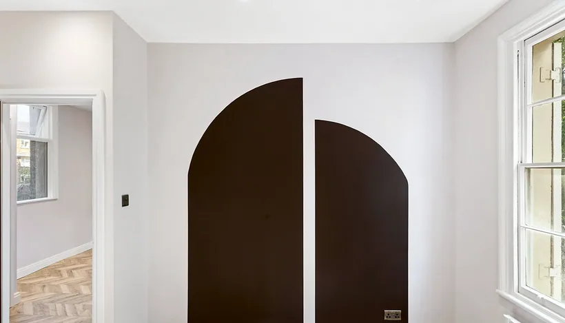 Arched dark feature wall in herringbone room, developer photography London