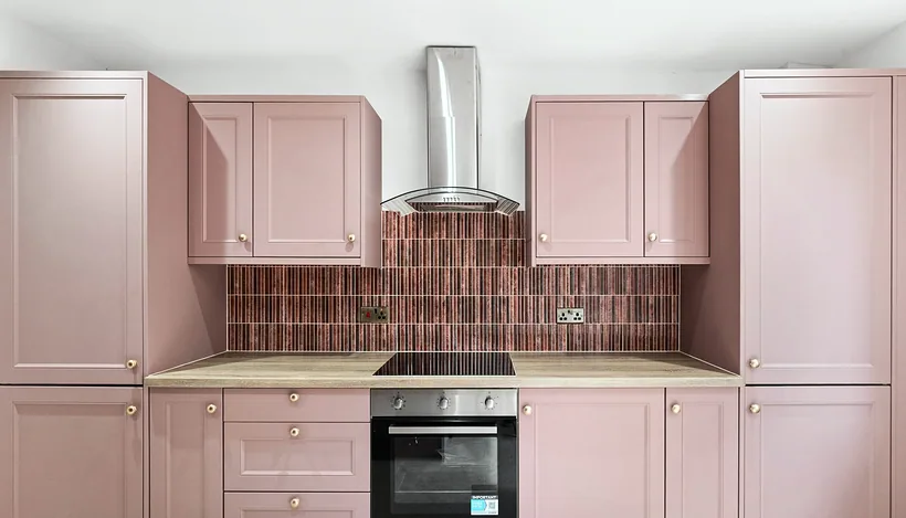 Blush pink shaker kitchen with terracotta tile splashback, developer photography London