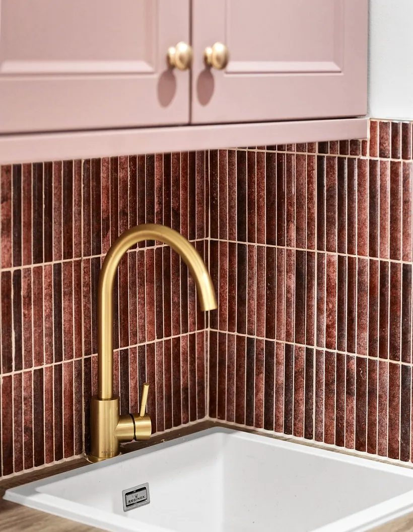Gold tap on terracotta stick tiles, detail, developer photography London