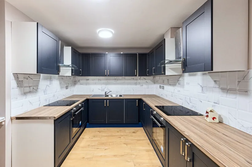 Navy L-shape kitchen with oak worktops, developer photography London