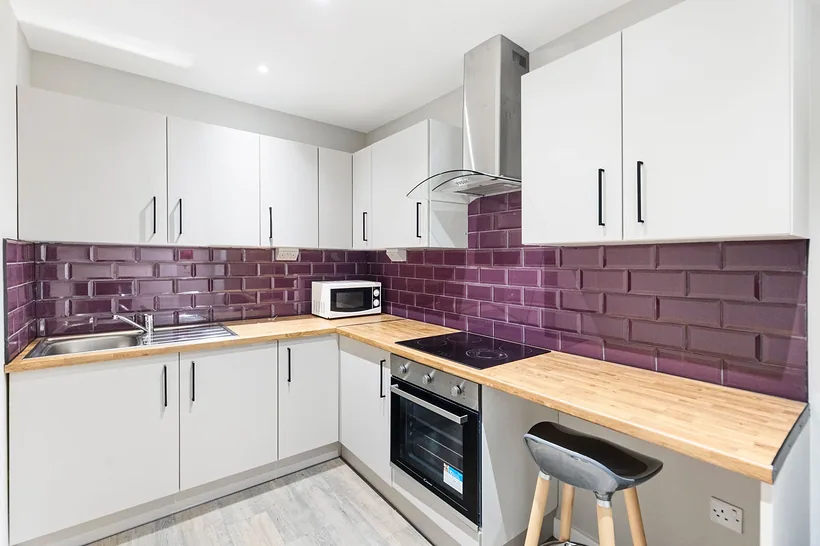 Plum metro tile kitchen with oak worktops, bold colour, developer photography London