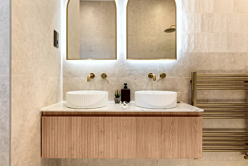 Twin basins on a fluted oak vanity with arched mirrors, interior photography London