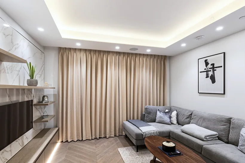 Living room with a marble media wall and floor-length curtains, interior photography London