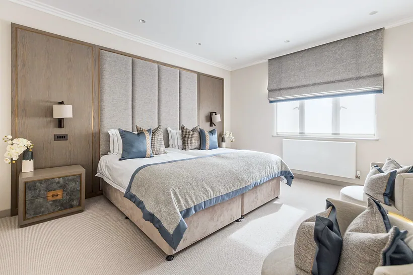 Hotel-style bedroom with tall upholstered headboard, interior photography London