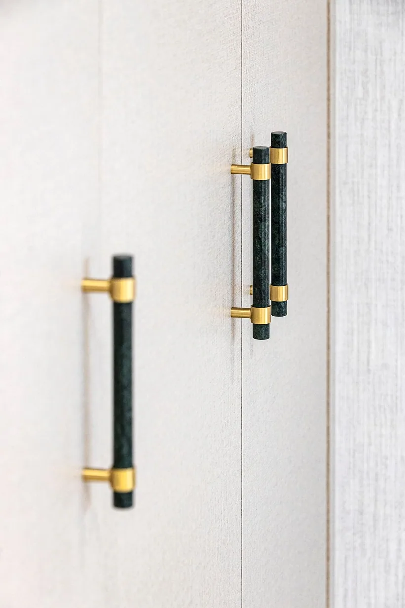 Brass and green-leather wardrobe handles, crafted detail, interior photography London