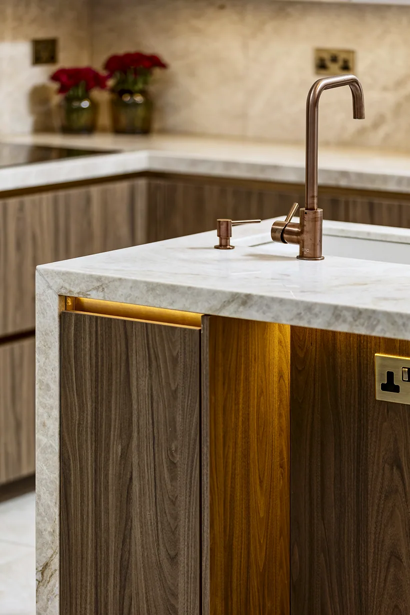 Walnut island with a marble worktop and copper tap, kitchen photography London