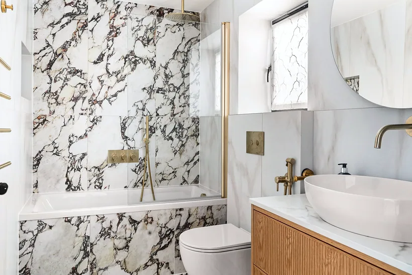 Bathroom in bold veined marble with brass taps, kitchen photography London