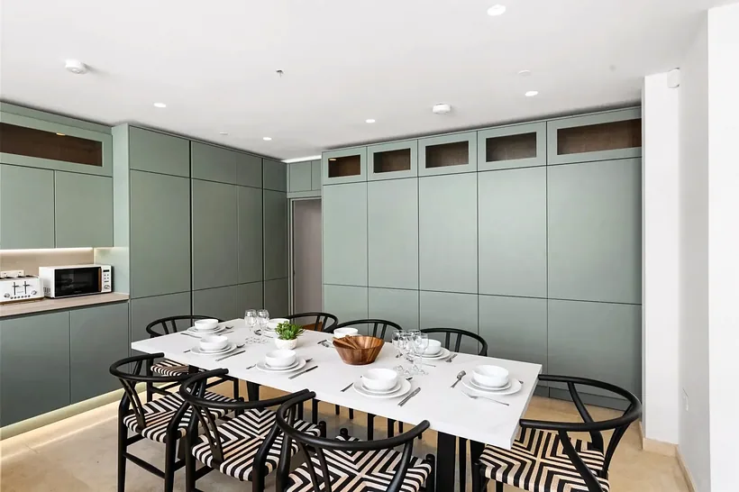 Sage green kitchen with a long dining table, kitchen photography London