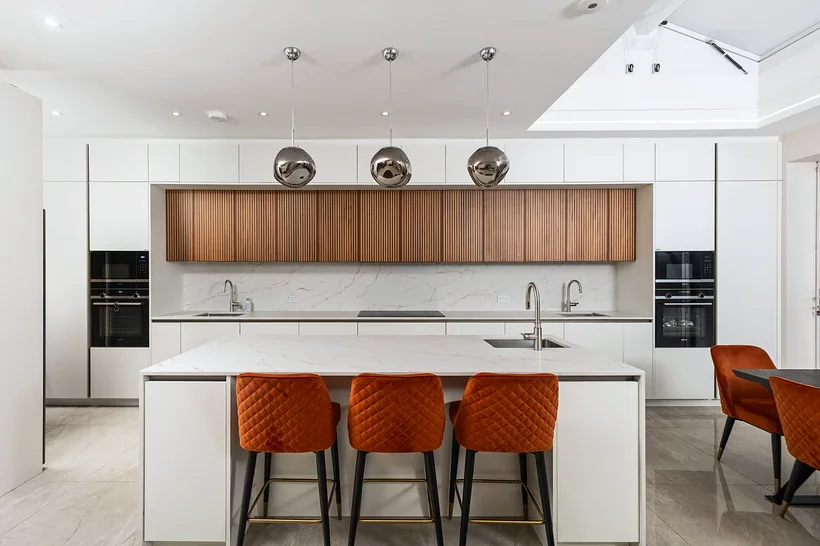 Orange stools against walnut kitchen, kitchen photography London