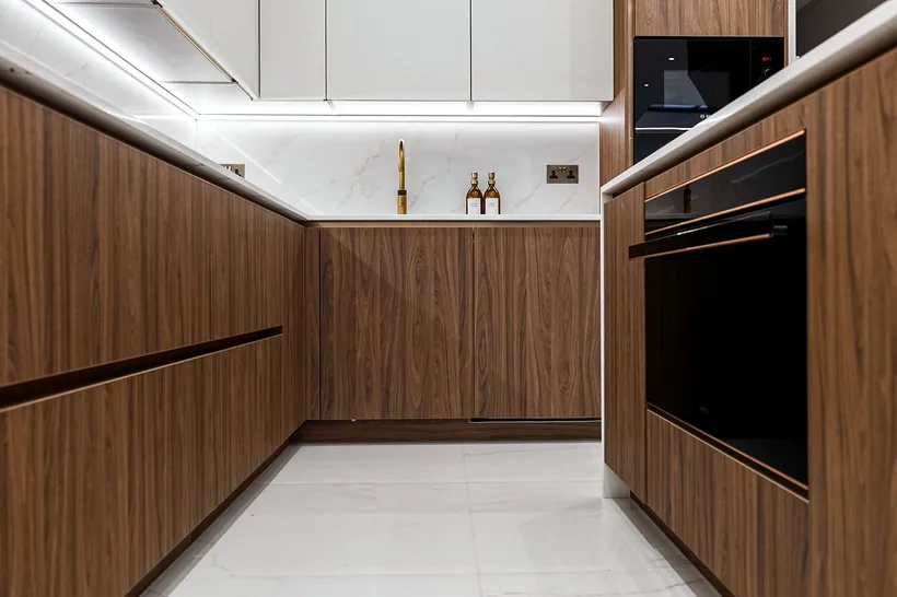 Walnut handleless galley, crisp lines, kitchen photography London