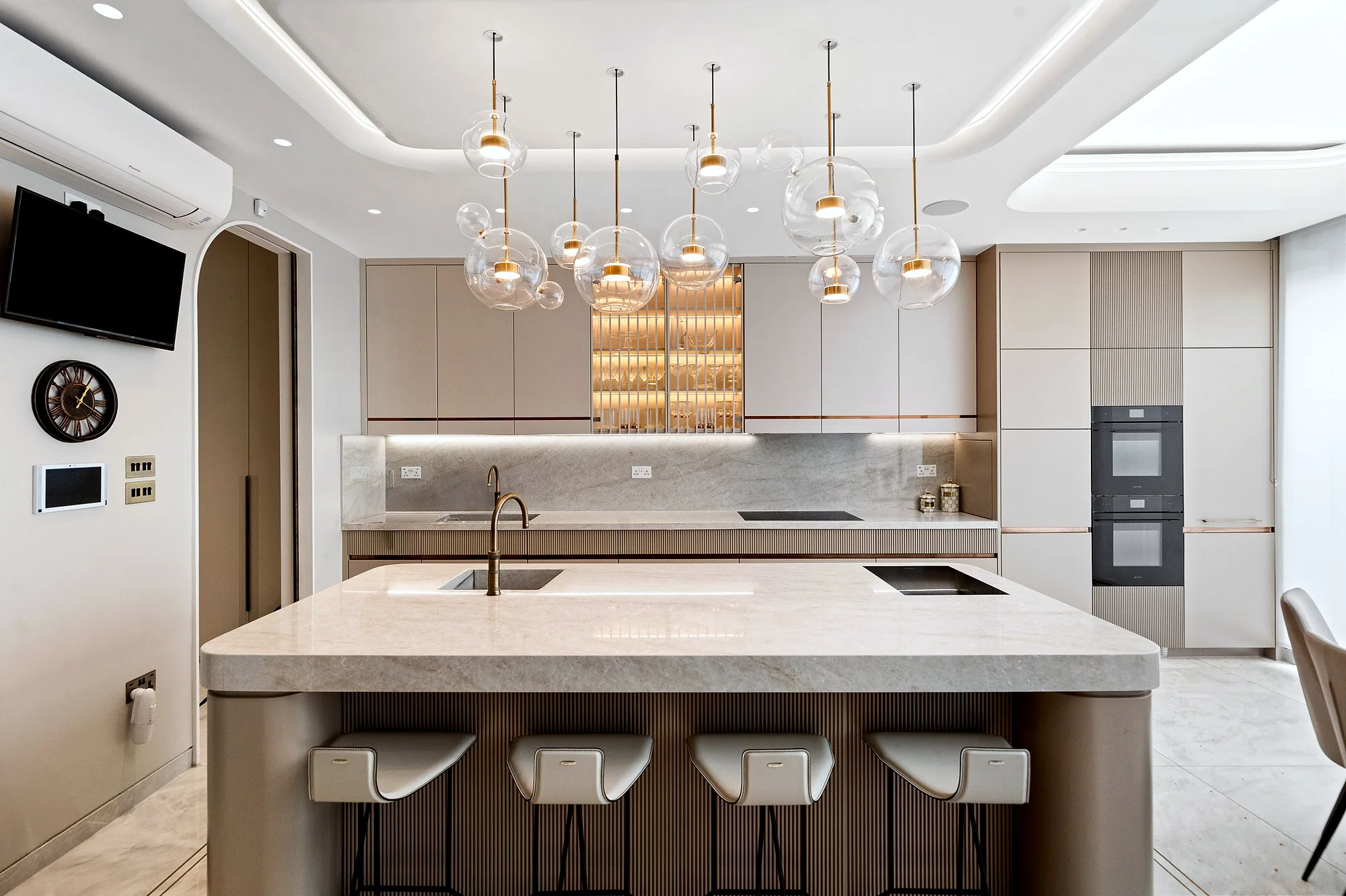 Kitchen island under a cluster of glass pendants, kitchen photography London