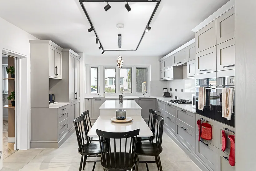 Bright open kitchen-dining with long table, estate agent photography London